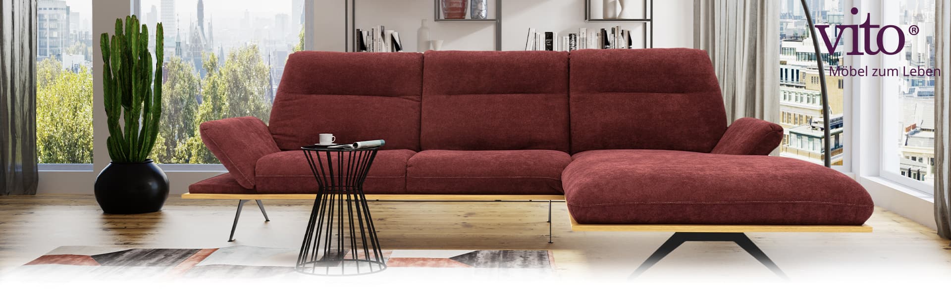 Ein rotes Stoffsofa steht in einem Wohnzimmer. Im Hintergrund ist eine Skyline zu sehen.