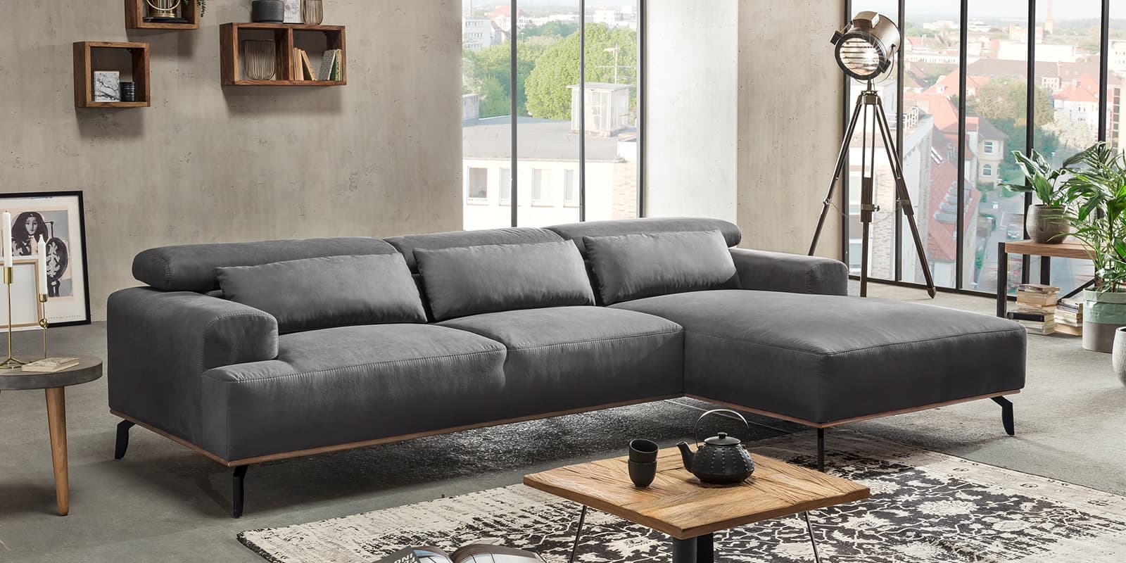 dunkelgraue Wohnlandschaft in einem Wohnzimmer mit Elementen des Industrial- und des Japandi-Styles