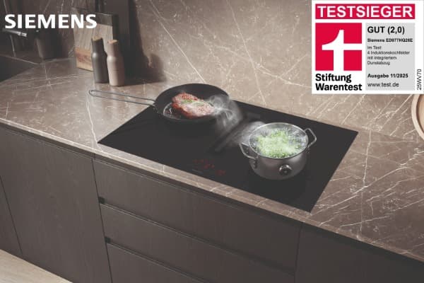 Siemens-Induktionskochfeld mit integriertem Dunstabzug, auf dem eine Pfanne und ein Topf mit dampfenden Speisen stehen; Testsieger-Siegel von Stiftung Warentest mit Bewertung „Gut (2,0)“.